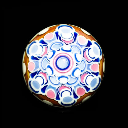 Colorful glass marble with intricate pink, blue, and white mandala pattern on black background.
