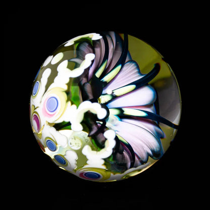Heady glass marble with intricate flower and colorful pattern against black background