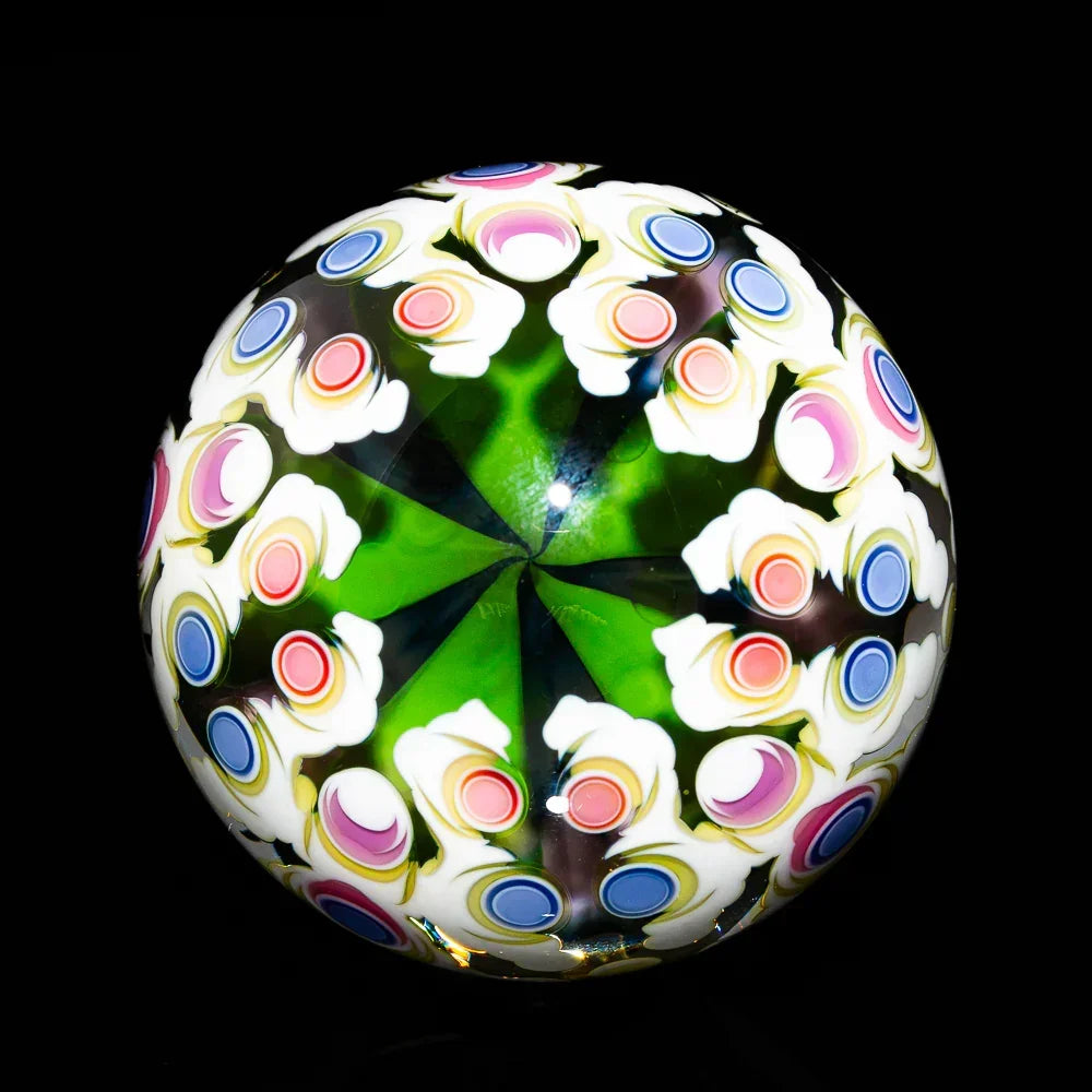 Colorful heady glass art marble with green, pink, blue, and white floral patterns on black background