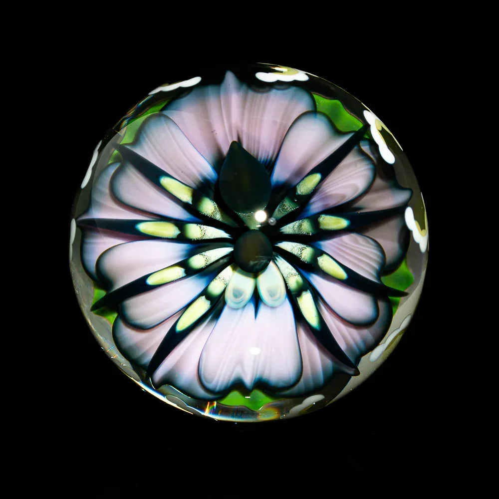 Handcrafted glass orb with intricate flower design, heady glass art on black background