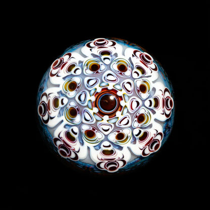 Intricate handblown glass marble with colorful, geometric patterns on a black background