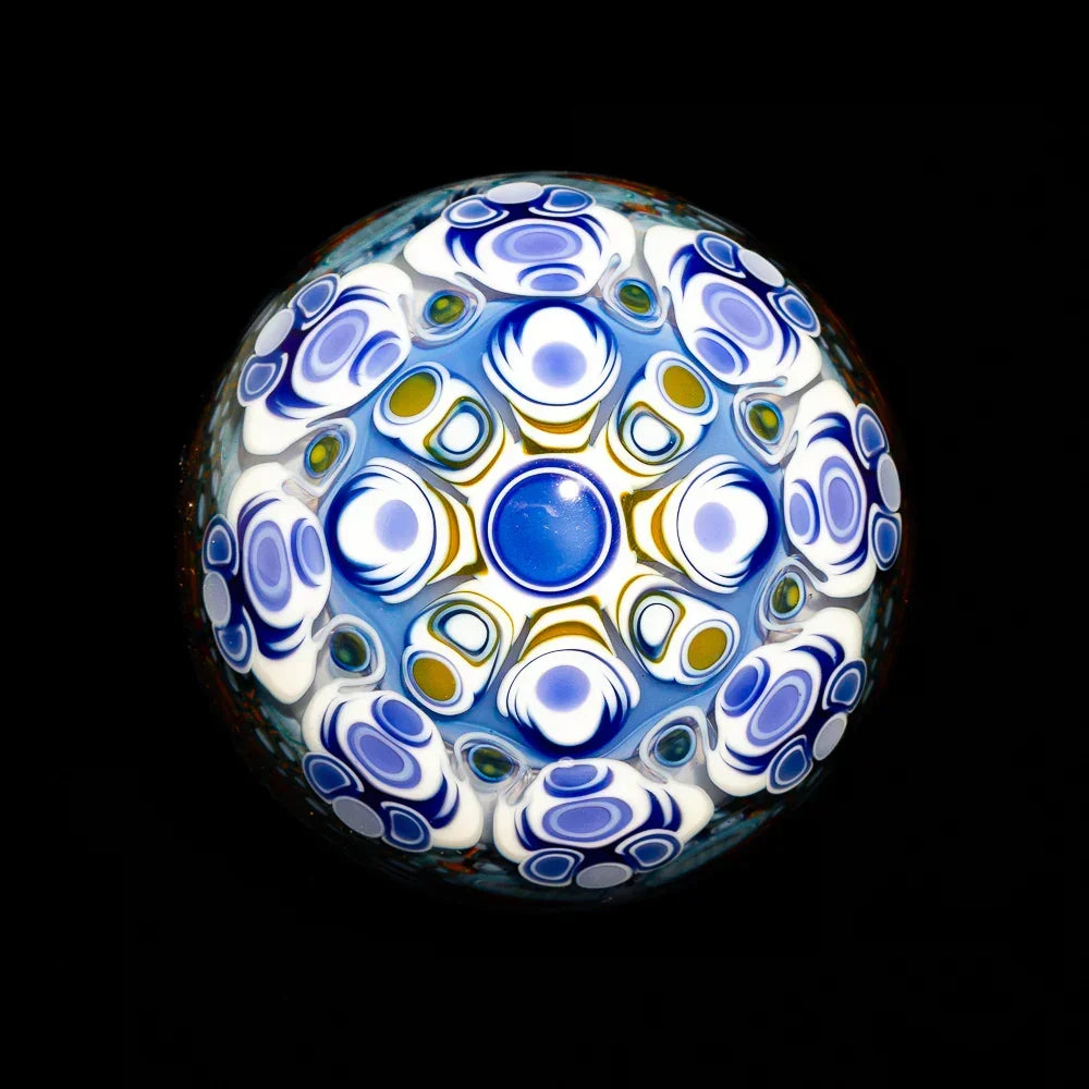 Colorful glass marble with intricate blue, white, and gold millefiori pattern on black background