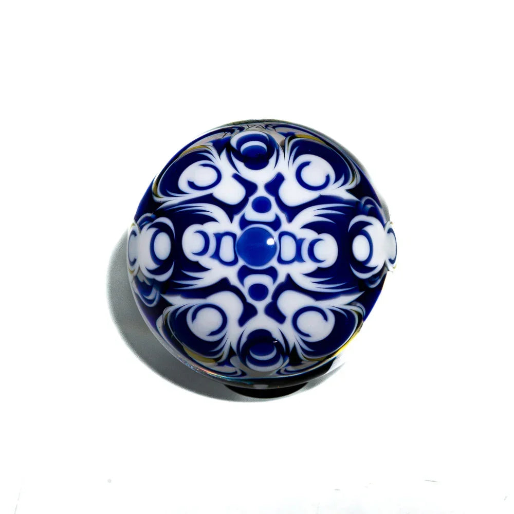 Blue and white patterned glass orb with intricate artistic design on a white background