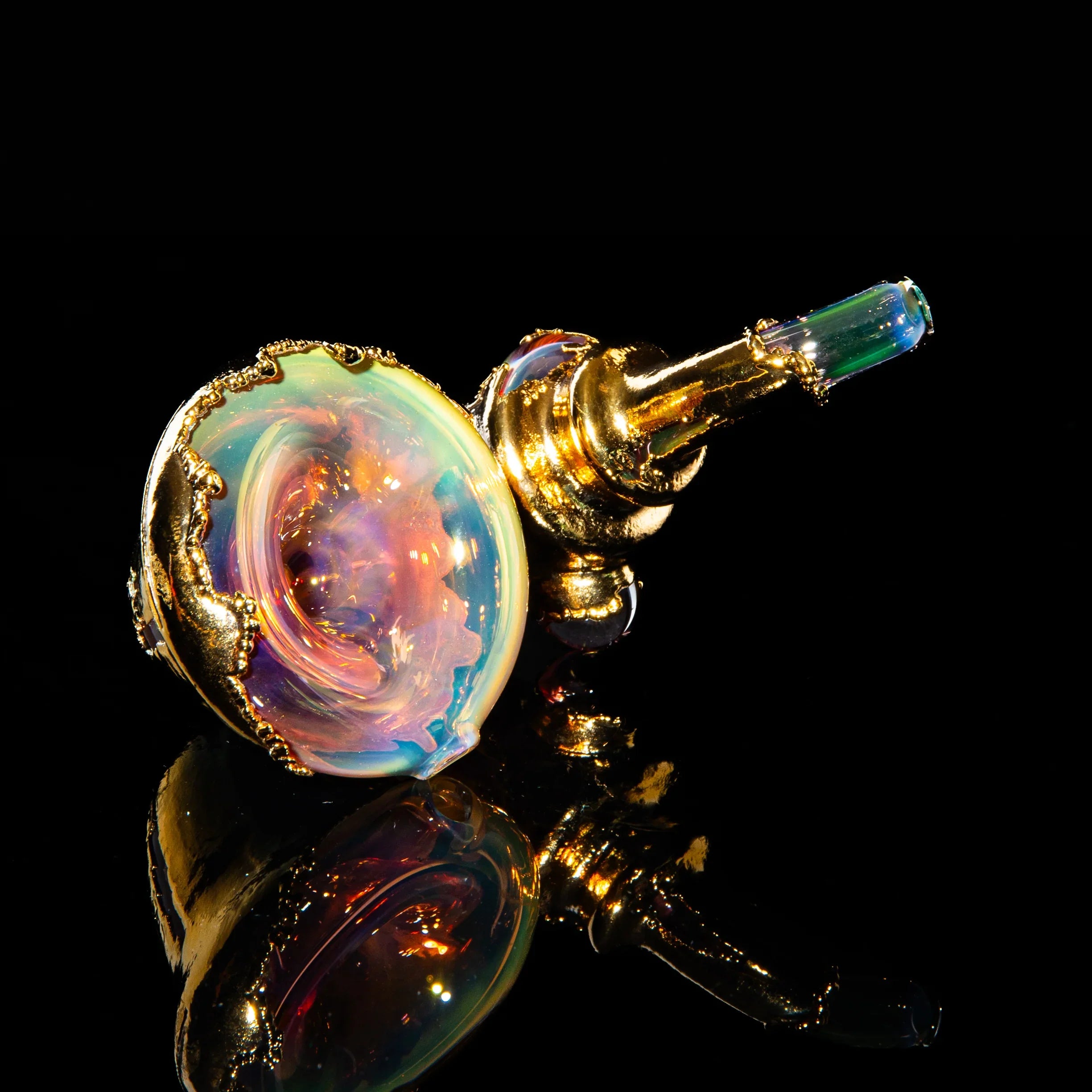 Gold sherlock hand pipe with iridescent glass and ornate details on black background