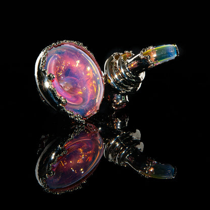 Iridescent glass sherlock pipe with metallic accents on a black reflective surface