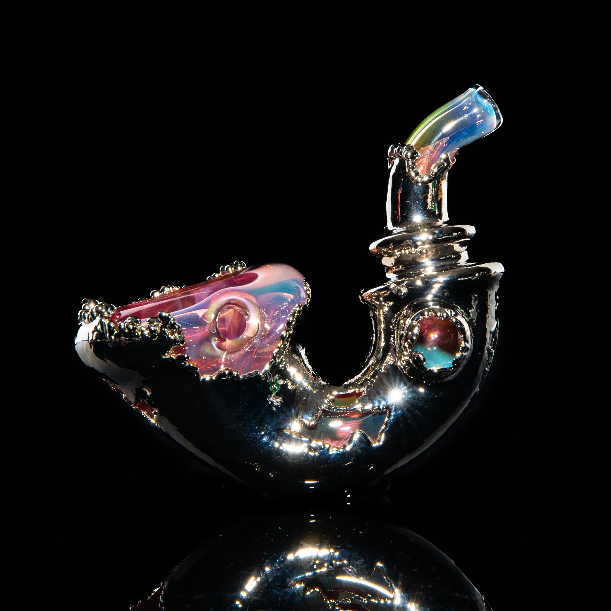 Handcrafted artistic glass sherlock pipe with metallic and iridescent details on black background.