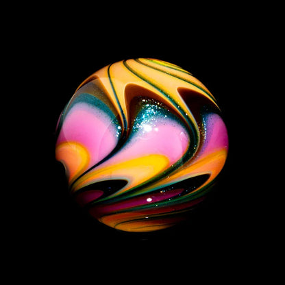 Colorful glass marble with pink, yellow, and glittery swirls on a black background.