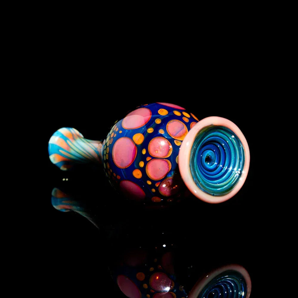 Colorful hand-blown glass pipe with vibrant dots and swirls on a black background