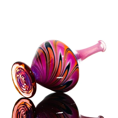 Hand-blown glass carb cap with vibrant pink, orange, and black swirl design.