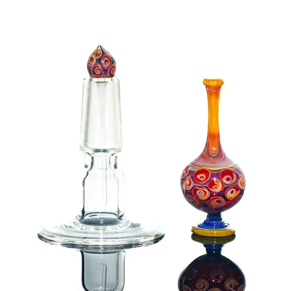 Handcrafted glass perfume jar and stopper with colorful swirled patterns on white background