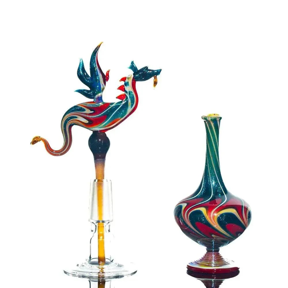 Colorful dragon-topped glass perfume jar and matching swirled glass vessel on white background.