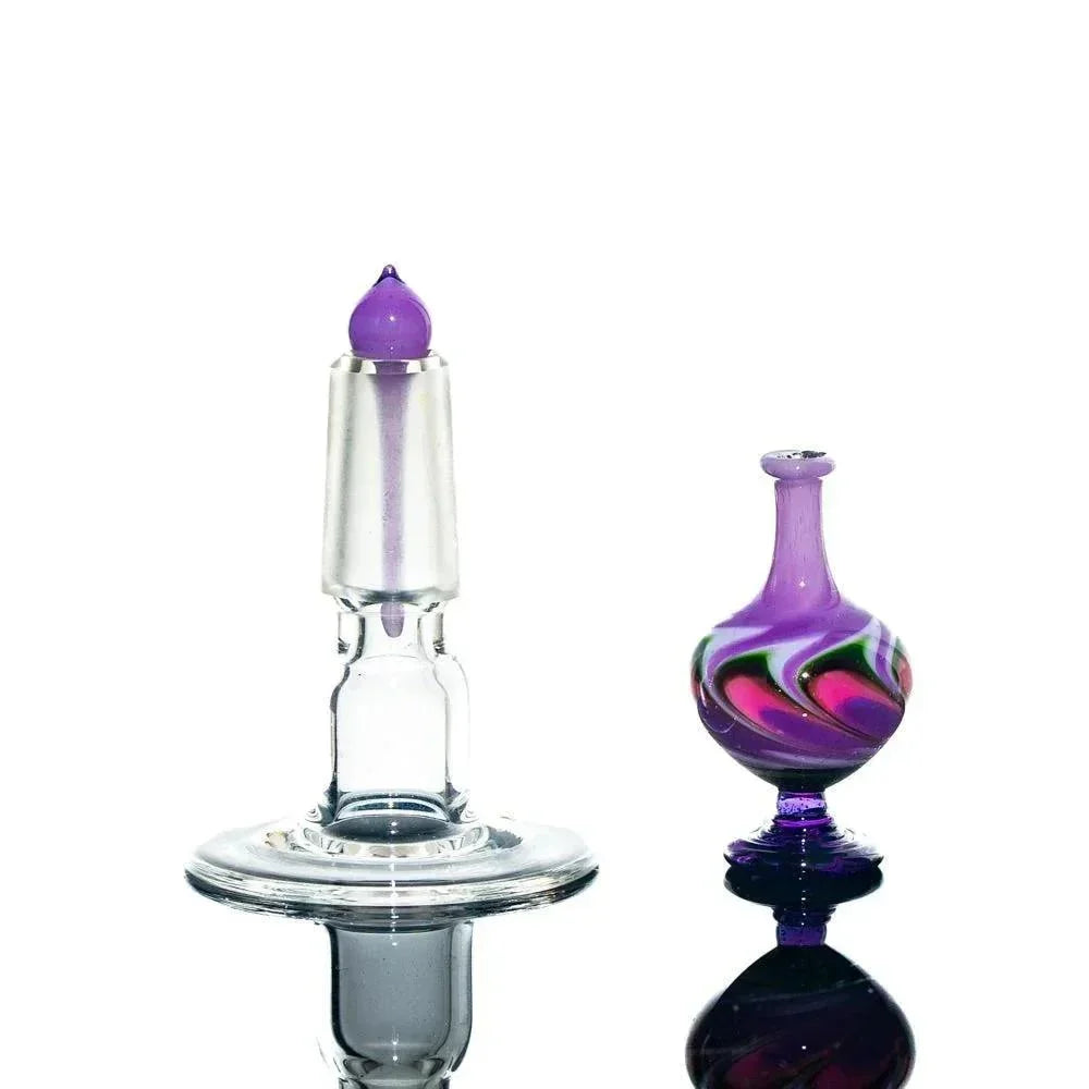Handblown glass perfume jar with stopper, purple swirl design, displayed on white background.