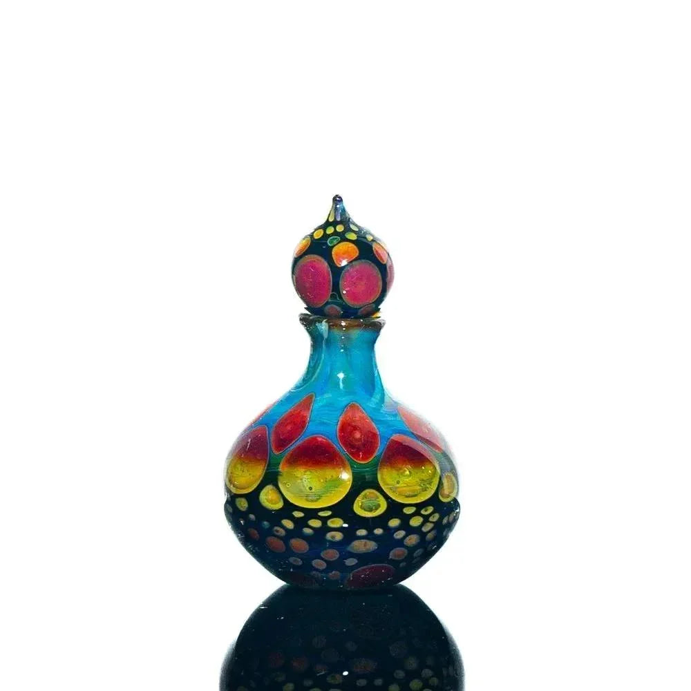 Colorful hand-blown glass perfume jar with vibrant dotted patterns on a white background.