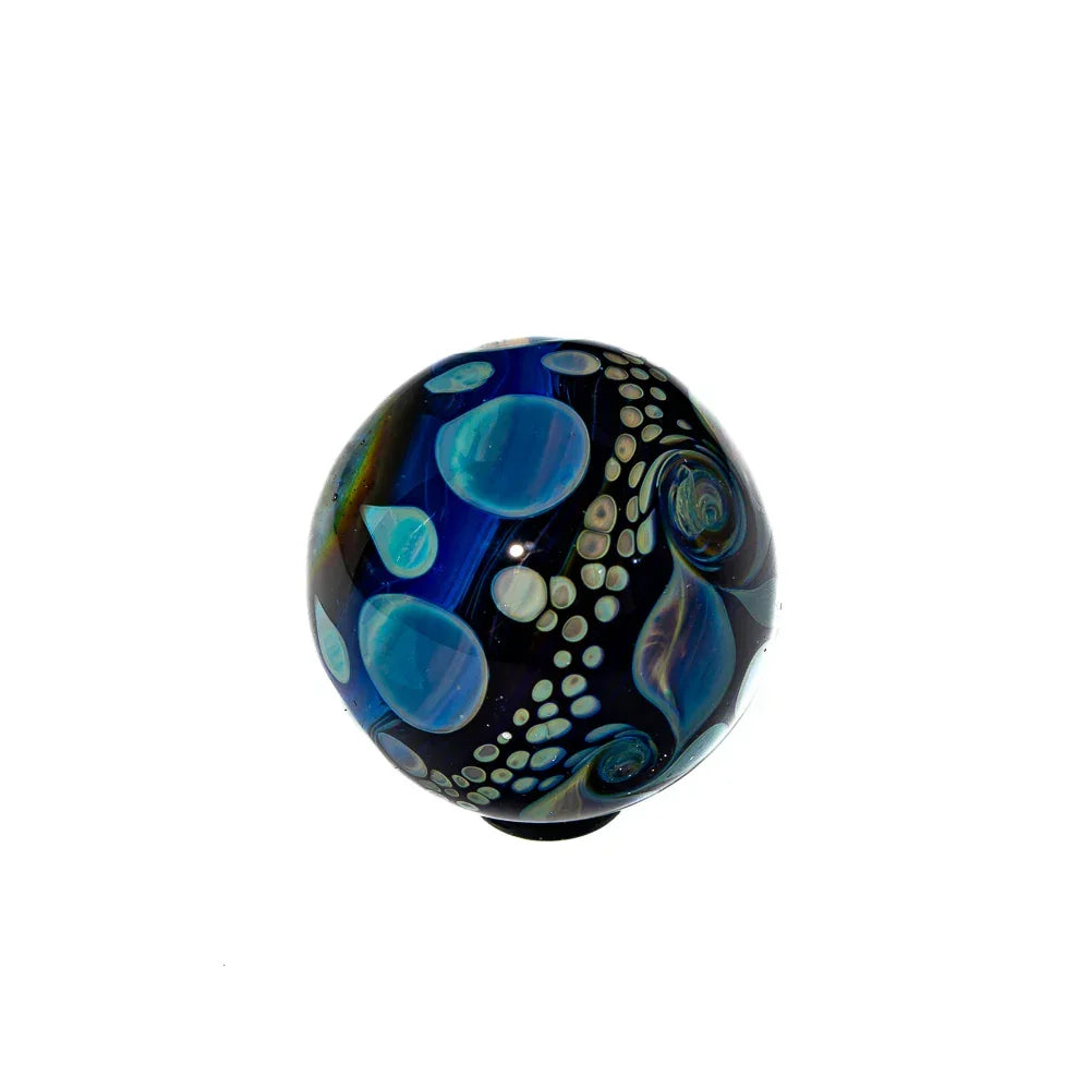 Hand-blown glass marble with blue and teal bubbles and abstract swirl patterns on black.
