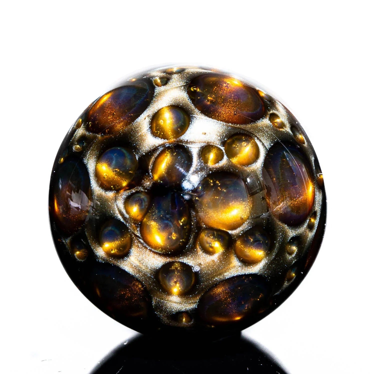 Art glass marble with gold and bronze bubble details on a white background