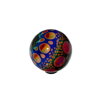 Hand-blown glass art marble with vibrant blue base and multicolor orb pattern