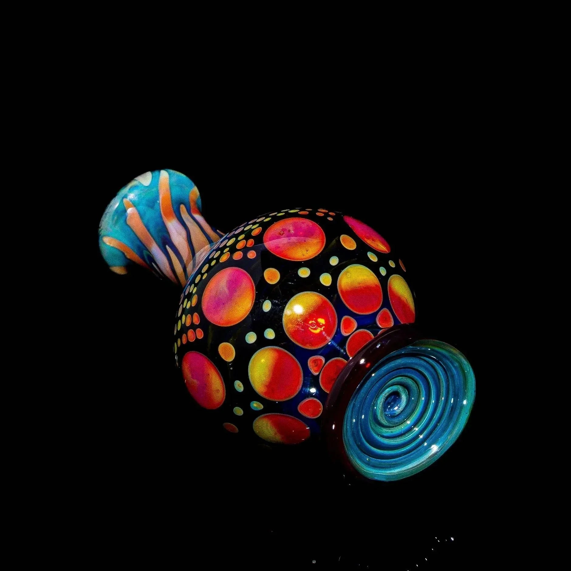 Handcrafted glass marble stand with vibrant sunset colors and hobnail pattern on black background