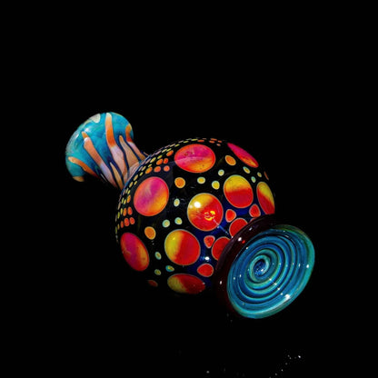 Handcrafted glass marble stand with vibrant sunset colors and hobnail pattern on black background