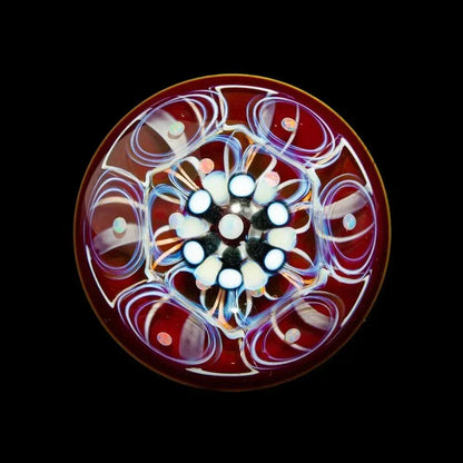 Handcrafted glass marble with opal accents and vibrant swirling patterns on a dark background