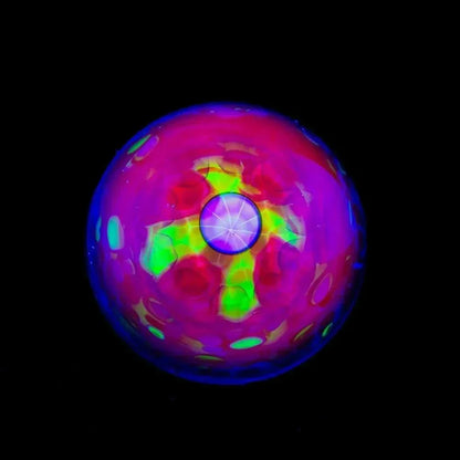 Colorful glass marble with vibrant UV-reactive patterns on a black background
