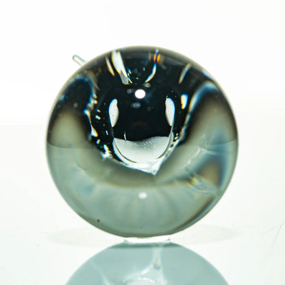 Handcrafted glass marble with abstract design, displayed on a white background
