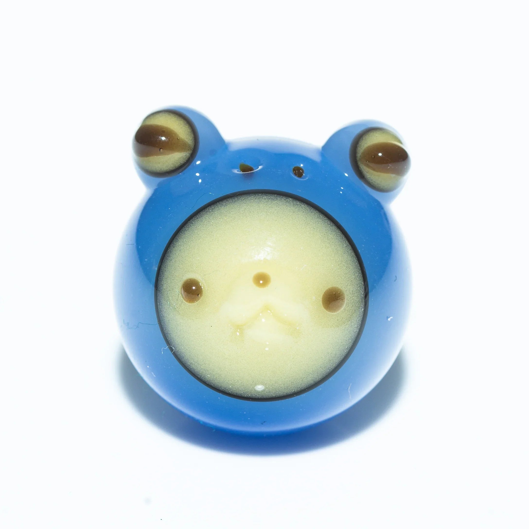 Blue glass frog carb cap with detailed face and bulging eyes on white background