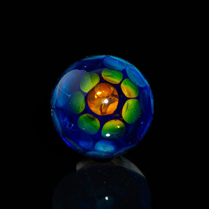 Colorful glass marble with blue, green, and orange details on a black background