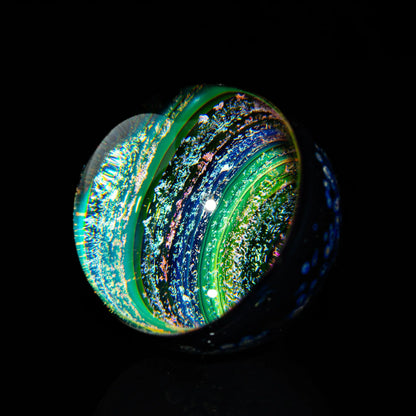 Heady glass marble with swirling blue, green, and iridescent galaxy-style patterns