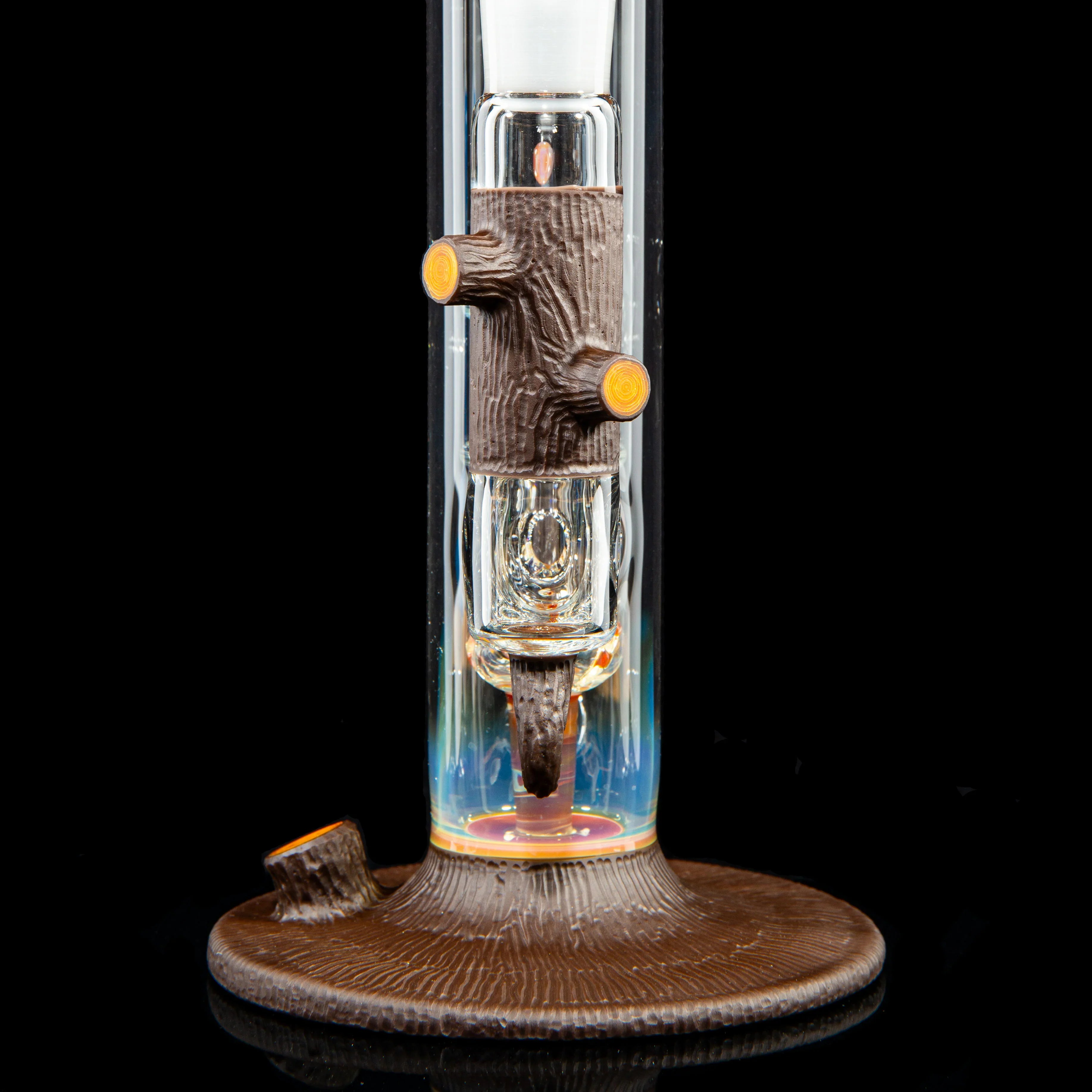 Artistic glass water pipe with detailed tree trunk and branch accents on black background