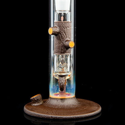 Artistic glass water pipe with detailed tree trunk and branch accents on black background