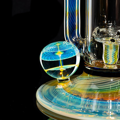 Artistic heady glass water pipe base with intricate blue and yellow linework and orb detail