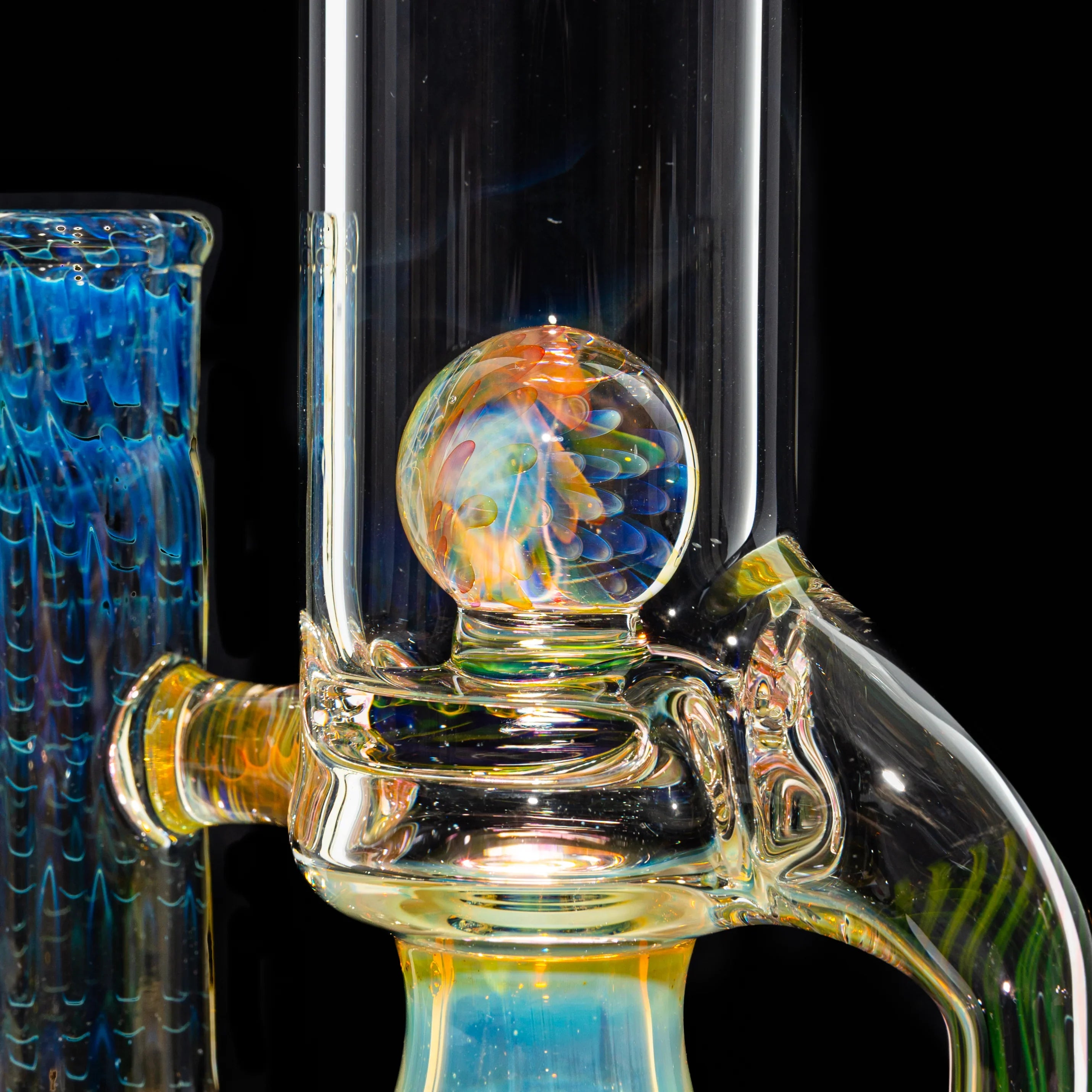 Close-up of intricate, colorful glass water pipe with vibrant marbled orb and blue accents