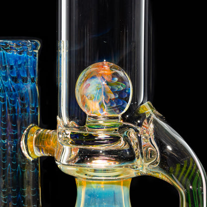 Close-up of intricate, colorful glass water pipe with vibrant marbled orb and blue accents