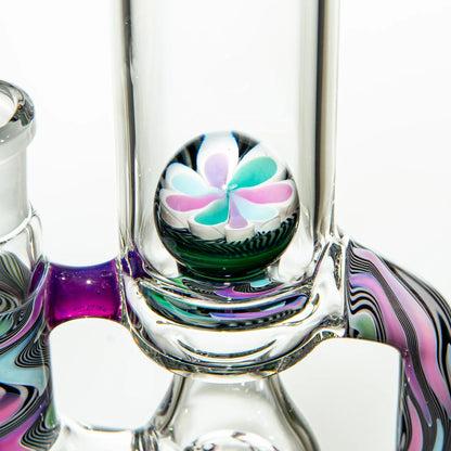 Close-up of colorful heady glass water pipe with flower marble accent and swirling patterns