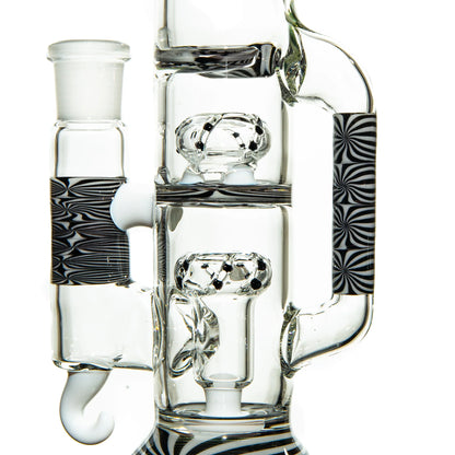 Clear glass water pipe with intricate percolators and black and white patterned accents