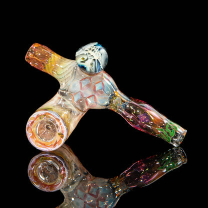 Colorful heady glass hand pipe with intricate patterns on a reflective black surface.