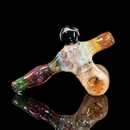 Colorful heady glass hand pipe with intricate patterns on a black reflective surface.