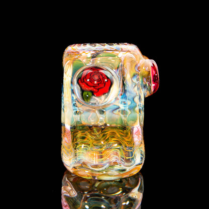 Heady glass pipe with vibrant colors and red rose marble detail on black background