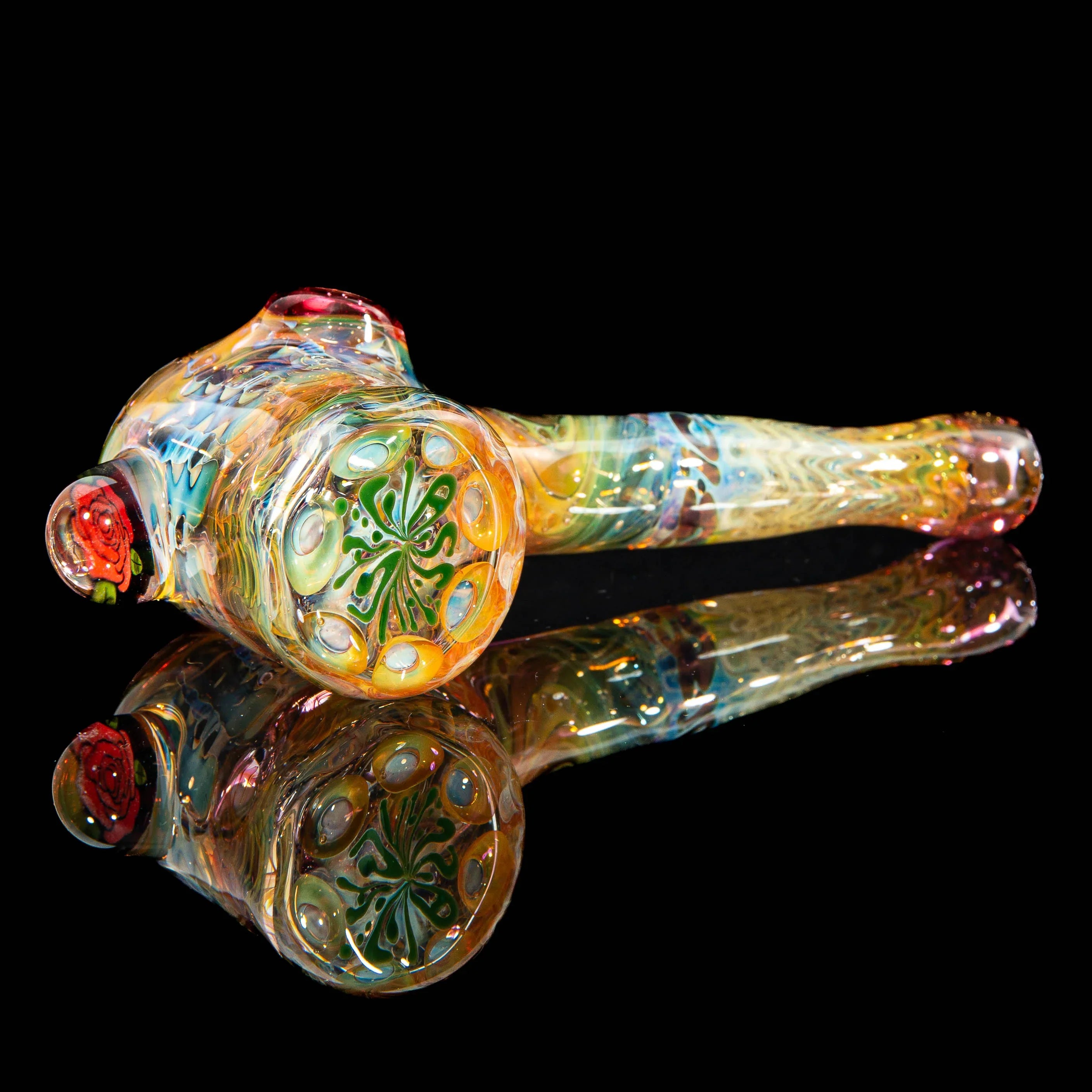 Colorful hand-blown glass pipe with intricate patterns and rose detail on a black background