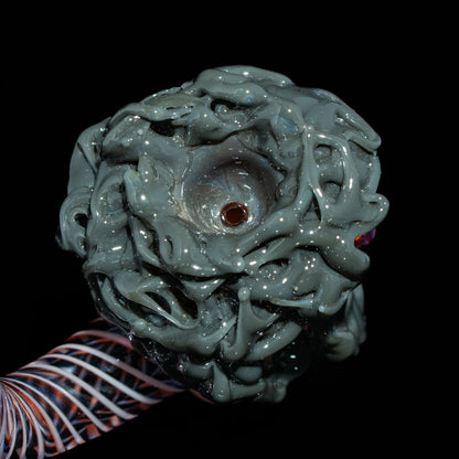 Hand-blown glass pipe with intricate gray sculpted bowl and twisted glass stem