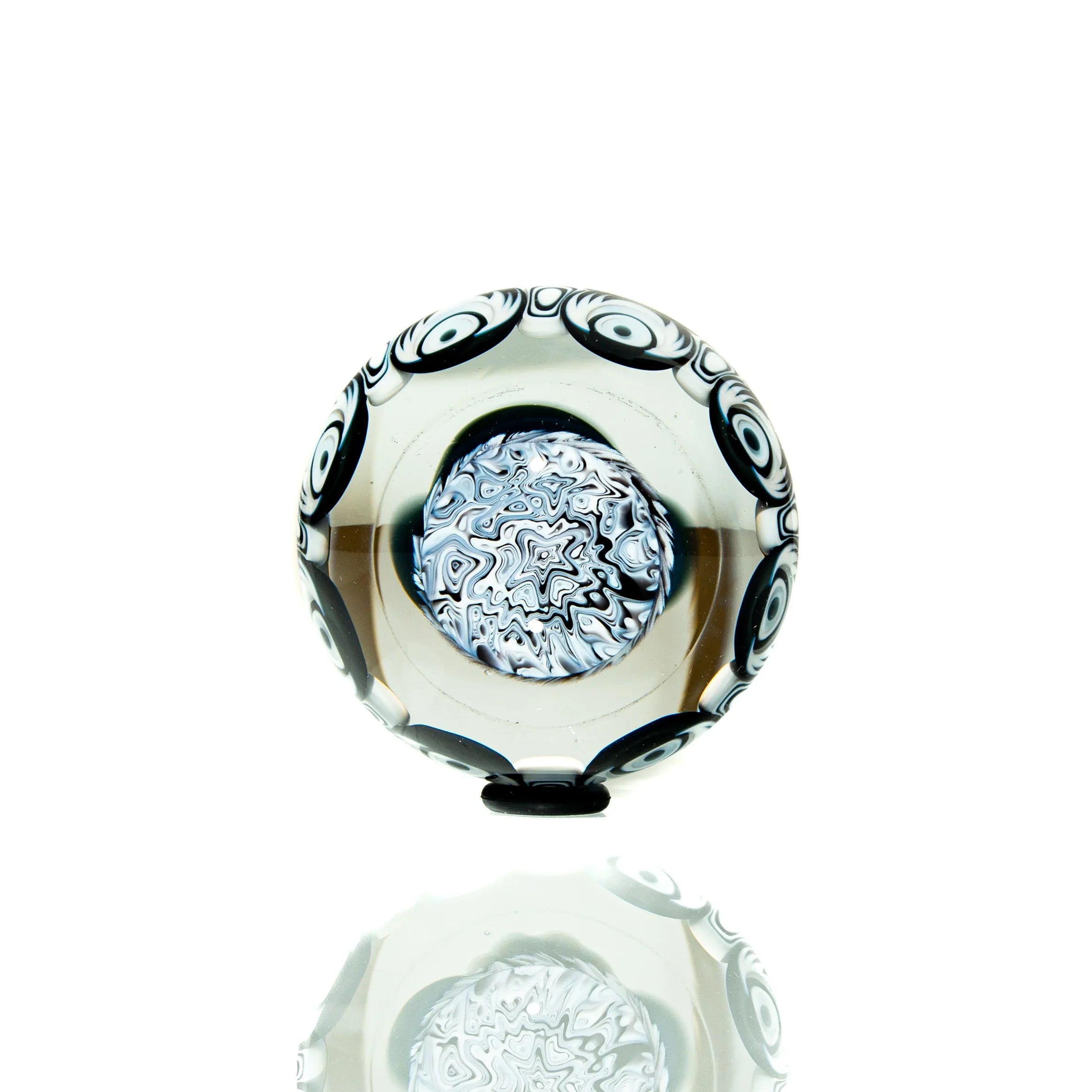 Handcrafted glass marble with black and white swirl pattern and intricate center design