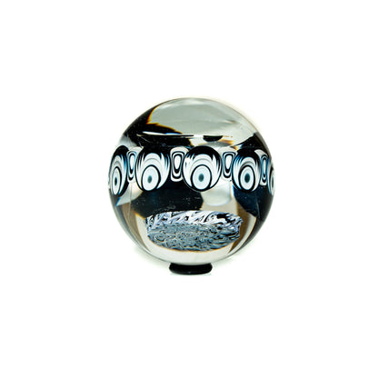 Handcrafted glass marble with black and white patterned design on a white background