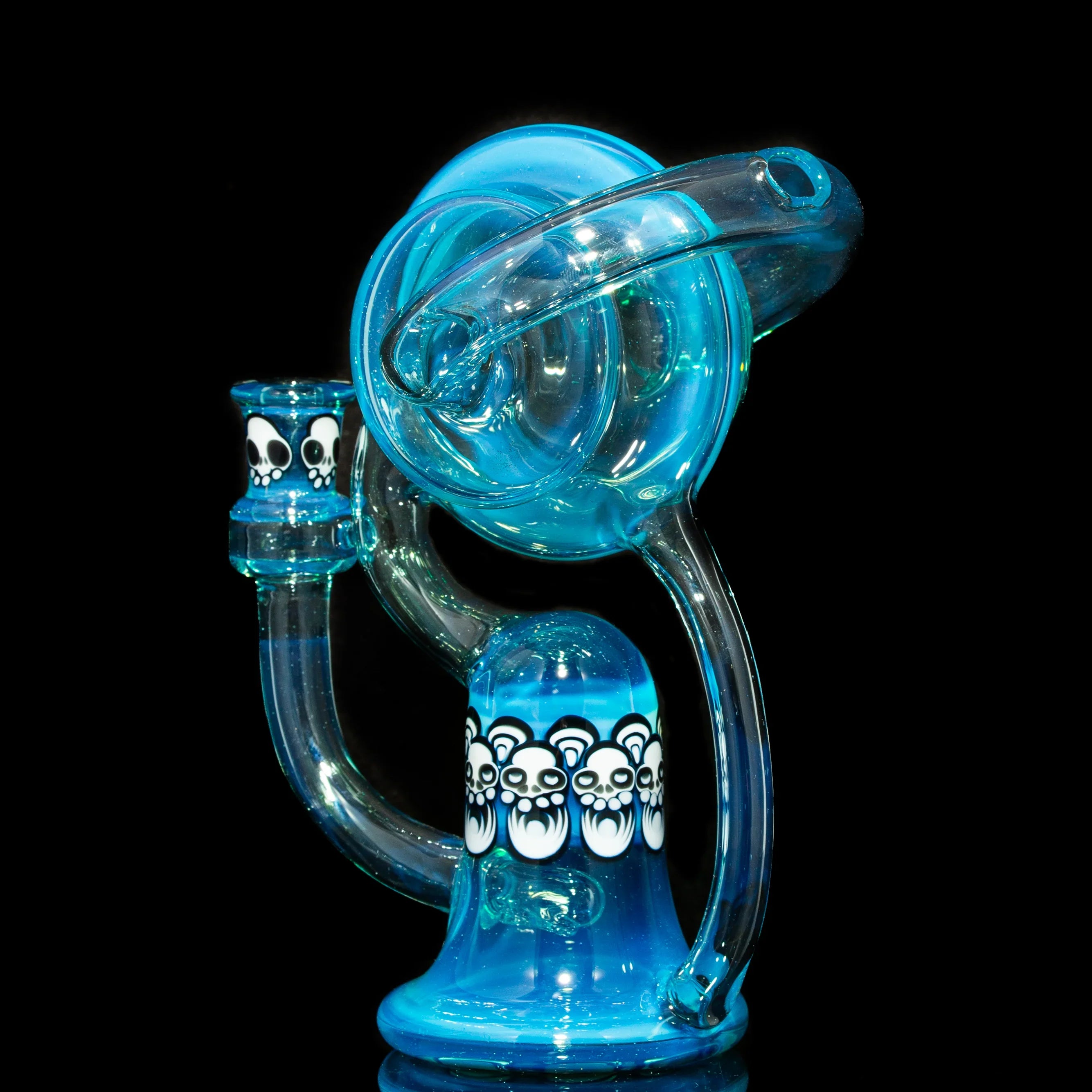 Blue glass recycler water pipe with white bear skull designs on black background