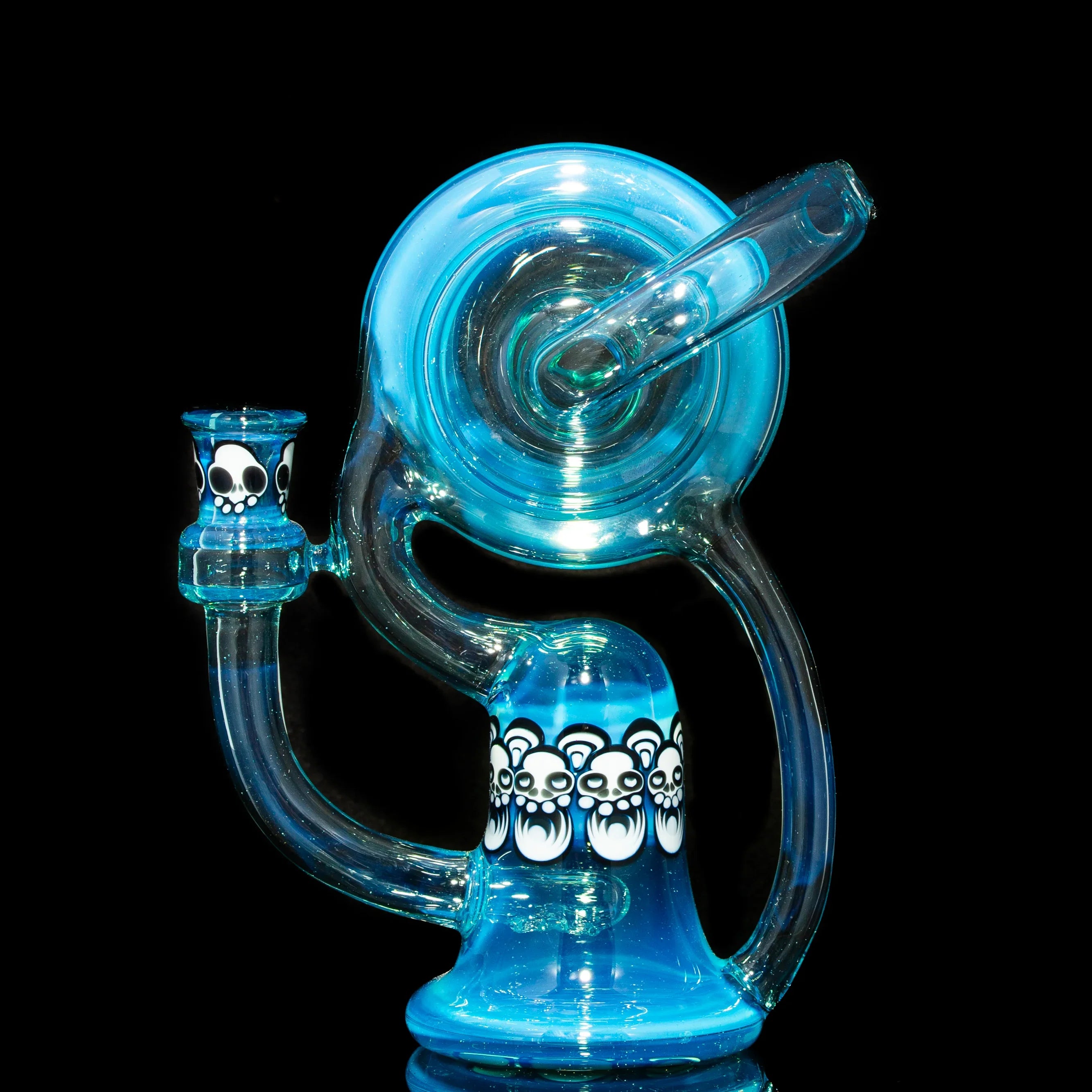 Blue glass recycler water pipe with white bear skull designs, displayed on black background