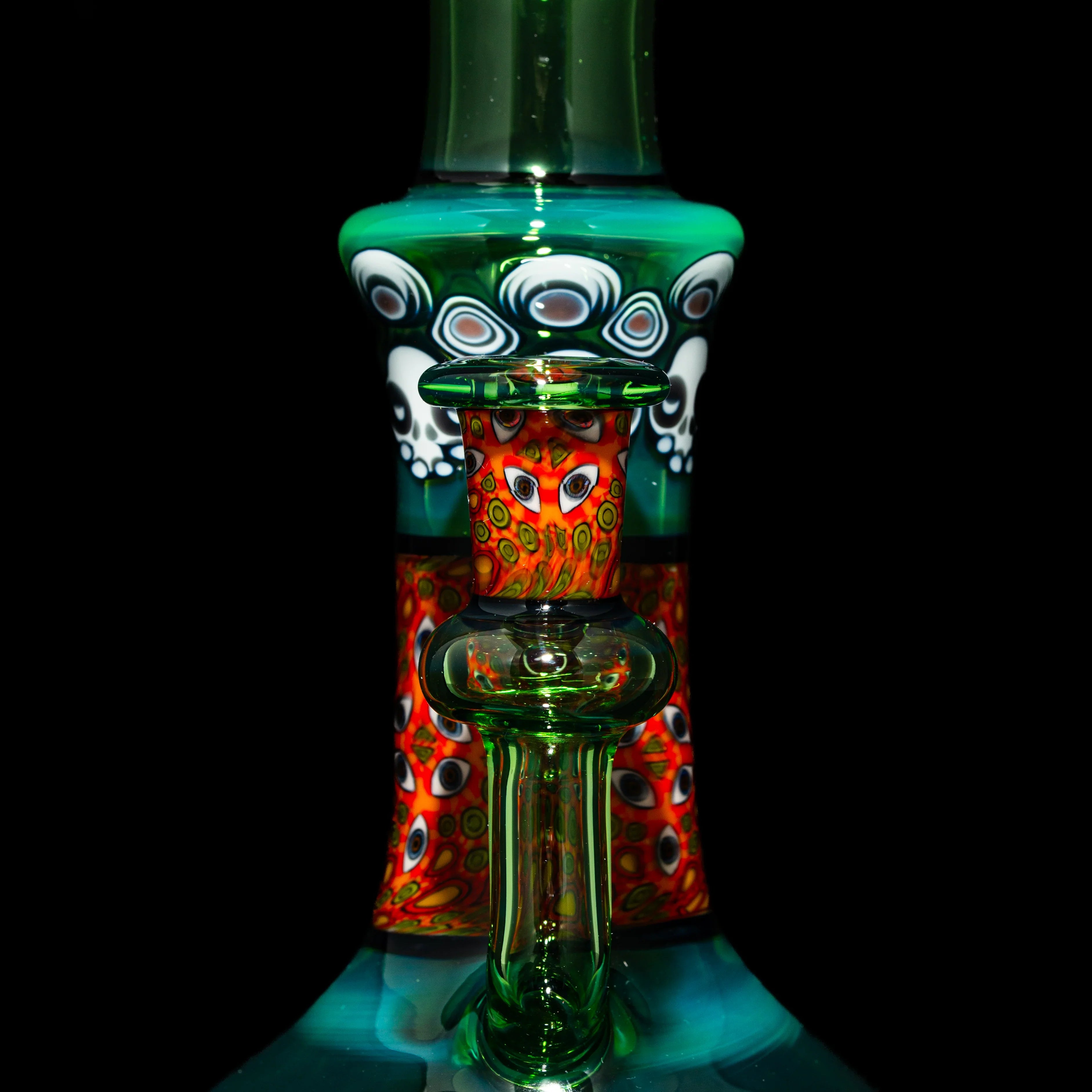 Heady glass water pipe with vibrant red, green, and patterned artwork, close-up view