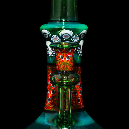 Heady glass water pipe with vibrant red, green, and patterned artwork, close-up view