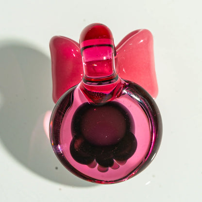 Pink glass carb cap with sculpted bow, used for dab rigs and smoking accessories