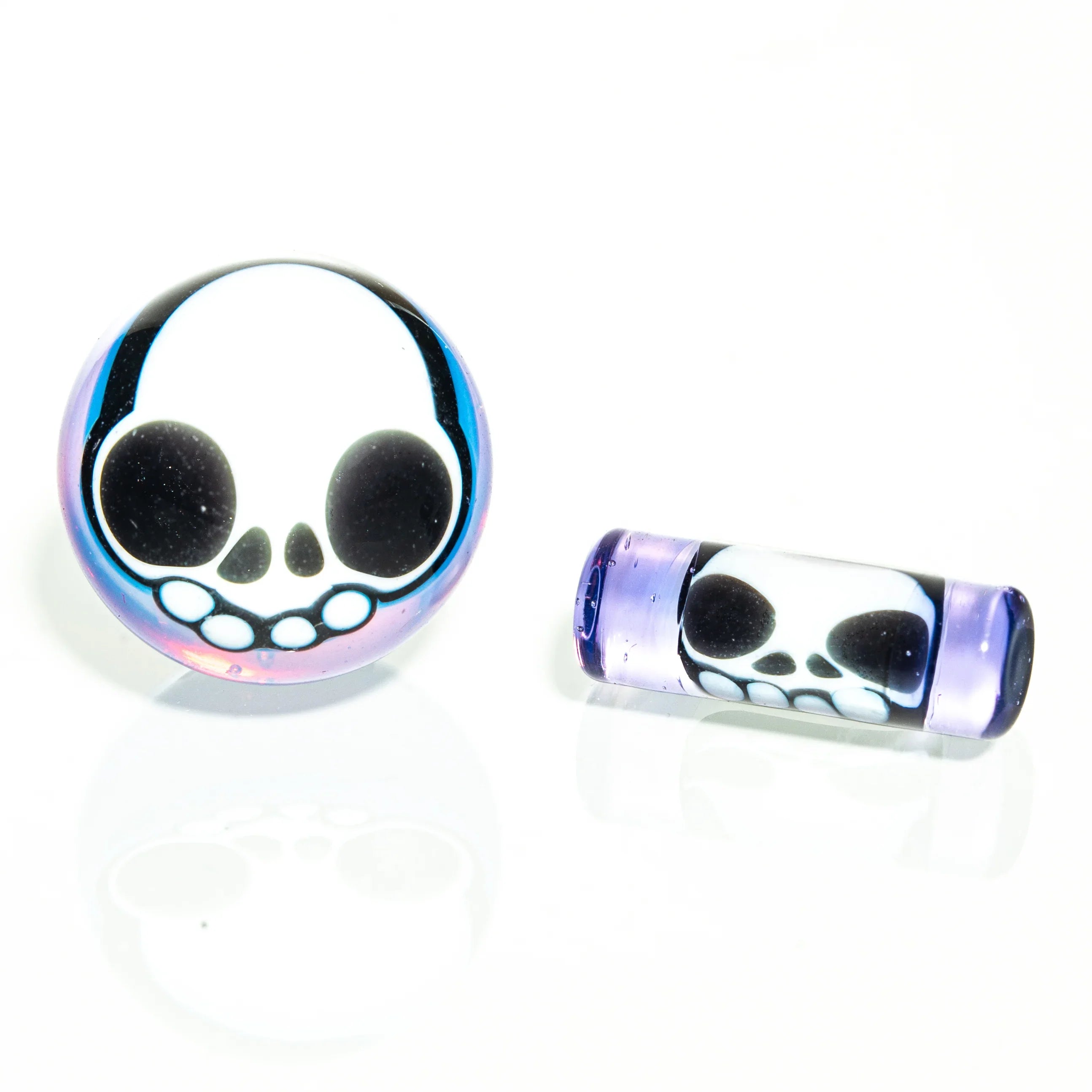 Heady glass carb cap and dab tool with purple accents and skull design on white background