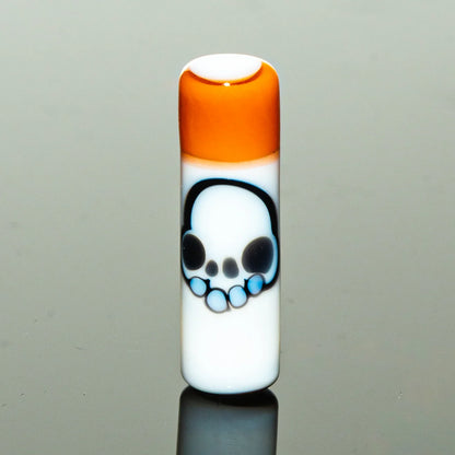 White glass accessory with orange top and blue skull design, reflective surface