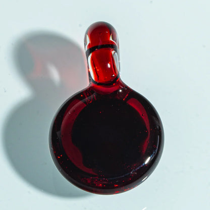 Red glass pendant carb cap with a loop handle on a white background